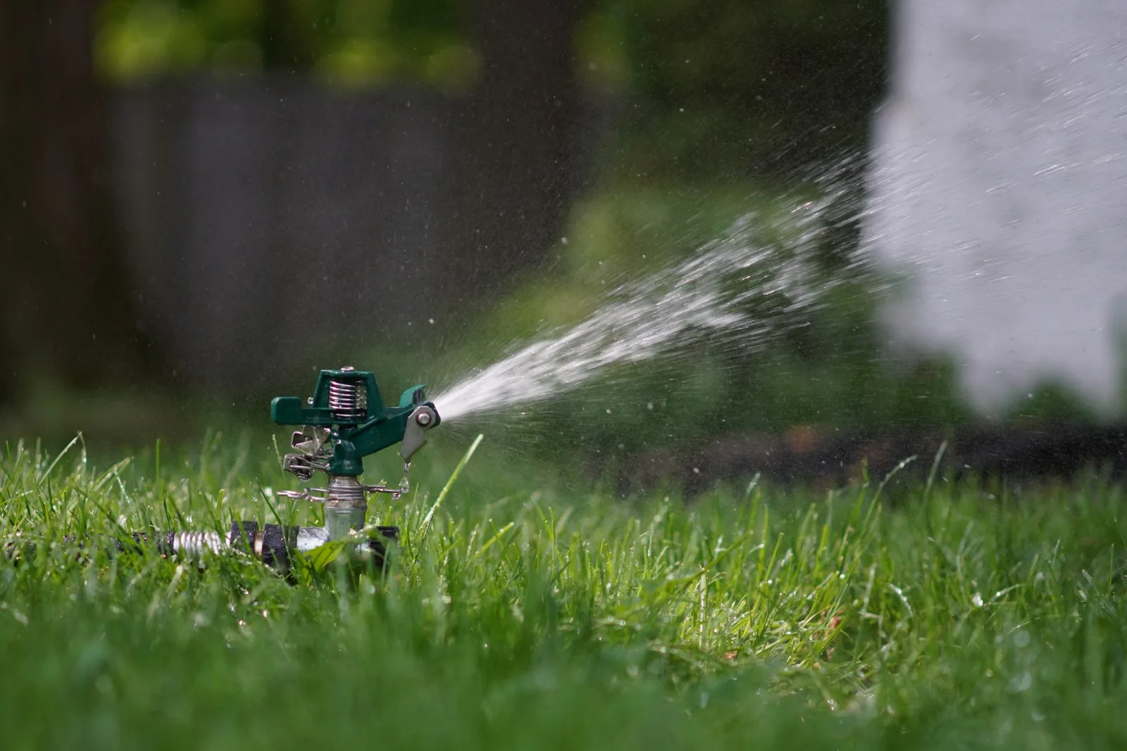 Yeşil çimlerde çalışan sprinkler sulama başlığı